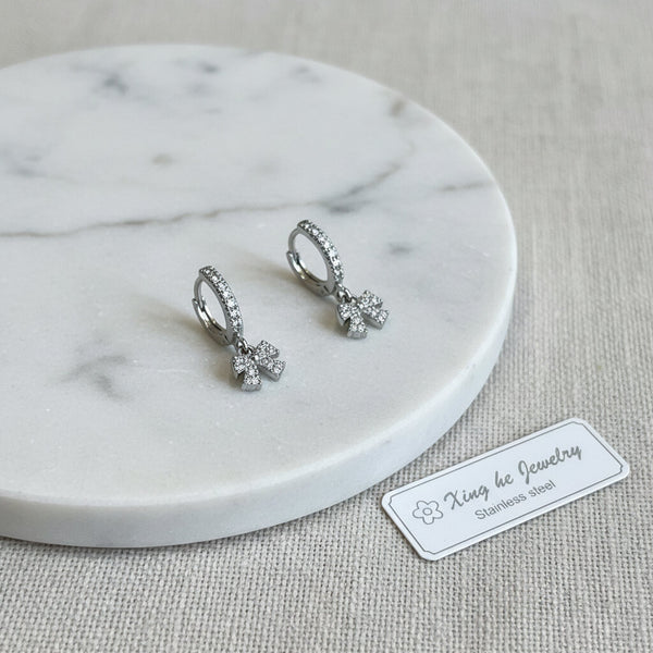 Orecchini Huggie Fiocco Brillante acciaio inossidabile – Gioielli Donna Tendenza 2026