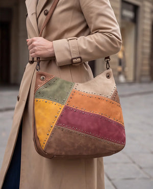 Borsa hobo patchwork multicolore 9440-107, portata sul braccio con trench beige