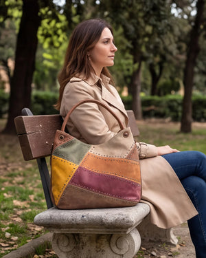Borsa hobo patchwork multicolore 9440-107, accanto a una donna sulla panchina