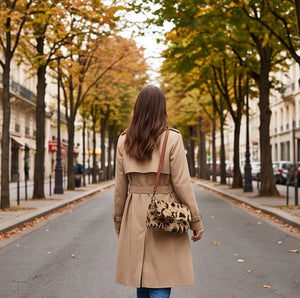 Borsa a tracolla animalier beige indossata con cappotto in una scena urbana