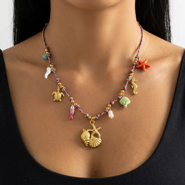 Brezza Marina - Collana Girocollo acciaio colore Oro con Ciondolo Conchiglia Bianca, Perle e Azzurro